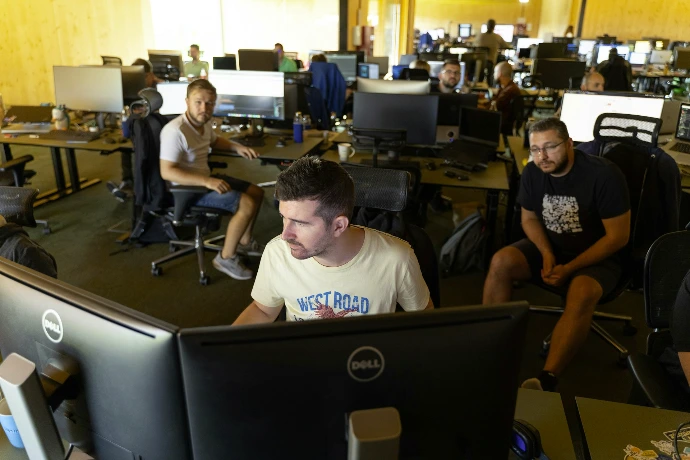 a group of men working on computers in an office